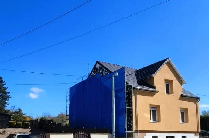 Travaux de rénovation de façade avec protection du chantier